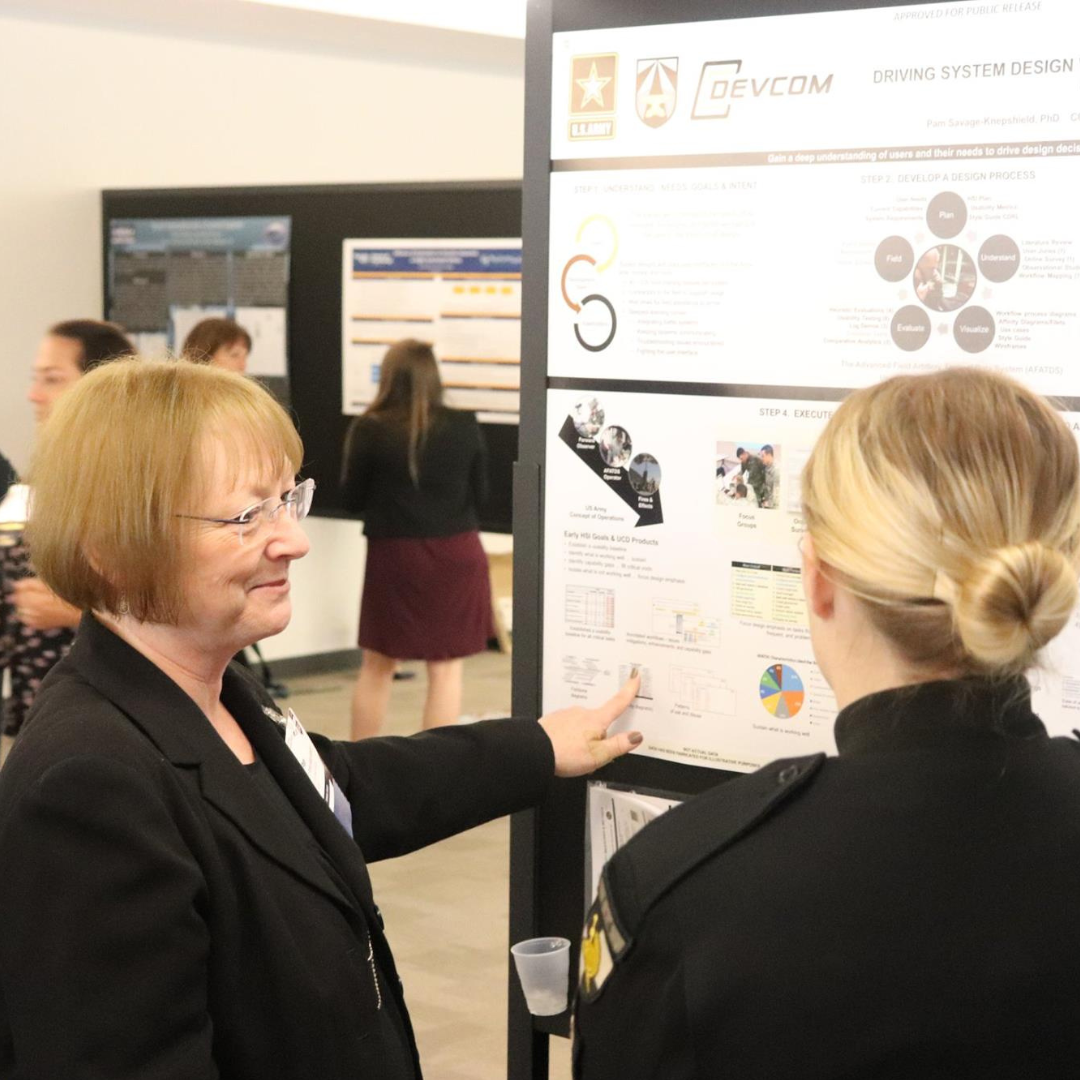 Two women have a conversation at the Human Systems Conference hosted by the NDIA Aberdeen Proving Ground Chapter